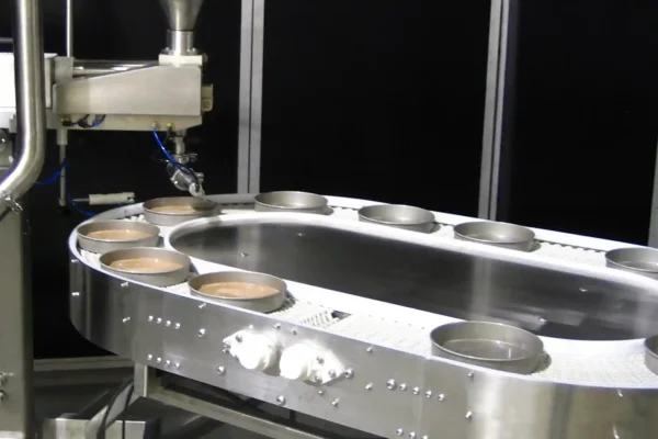 Racetrack modular belt conveyor with depositor for cake batter filling
