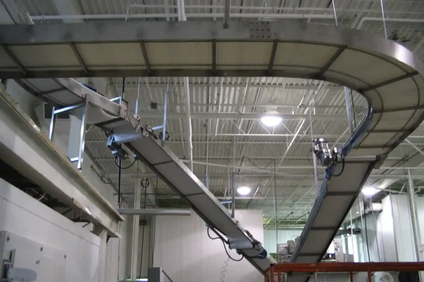 Suspended cooling conveyor system to save production floor space