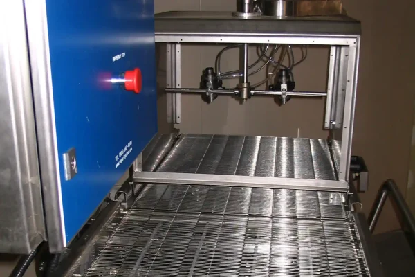 Open wire mesh conveyor for pastry glazing with recirculating spray system