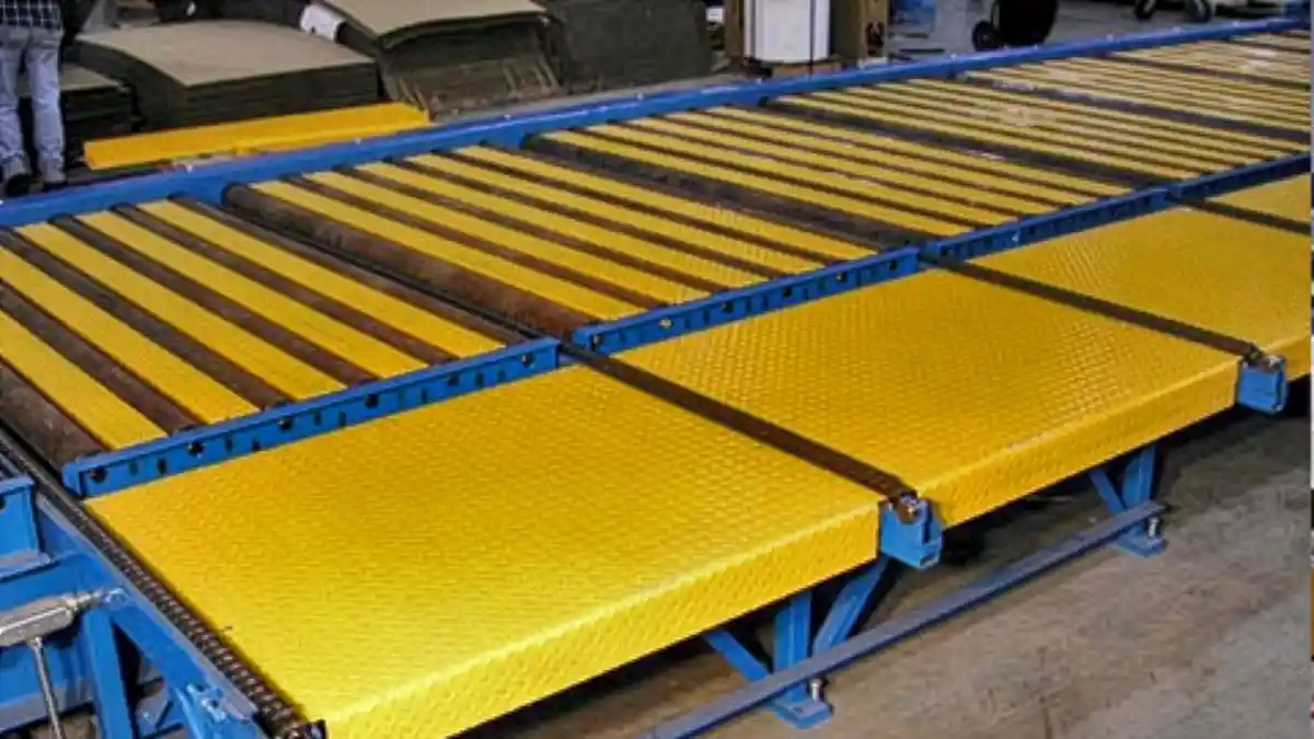 Heavy-duty multi-strand chain conveyor transporting lumber bundles and wood panels in manufacturing plant